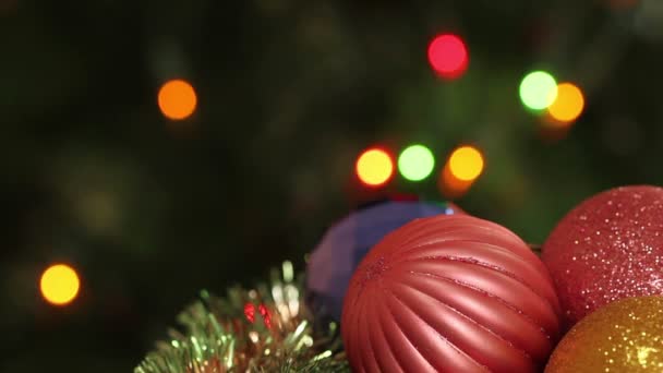 Різдвяні кульки і ялинка з гірляндами блимає. Тло — стокове відео