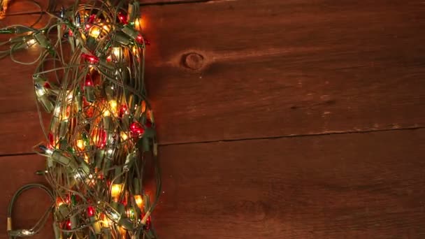 Guirnalda intermitente en el suelo de madera. Fondo de Navidad — Vídeos de Stock