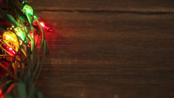 Guirnalda intermitente en el suelo de madera. Fondo de Navidad — Vídeos de Stock