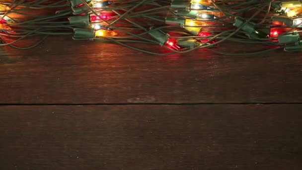 Guirnalda intermitente en el suelo de madera. Fondo de Navidad — Vídeos de Stock