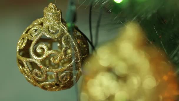 Durchbrochene Goldkugeln auf einem Weihnachtsbaum — Stockvideo