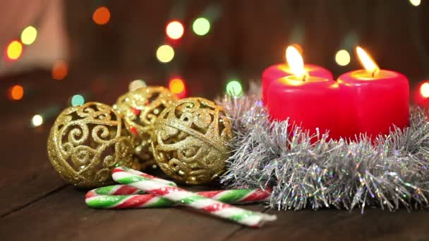Burning candles and Christmas decorations on a tree background. — Stock Video