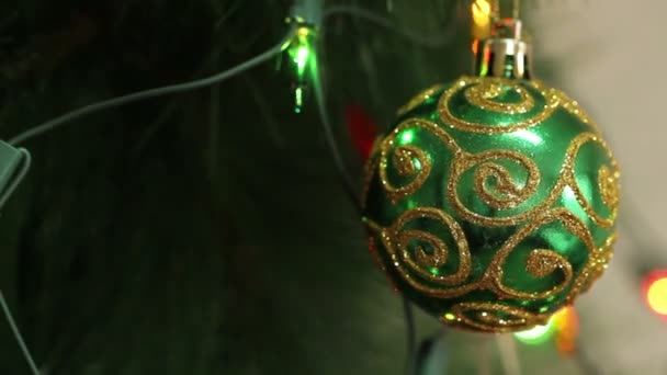 Grüne Kugel mit Funkeln auf einem Weihnachtsbaum — Stockvideo