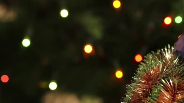 Kerstboom klatergoud garland in de achtergrond knippert — Stockvideo