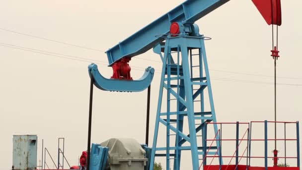 Working oil pump in a field on a bright background. — Stock Video