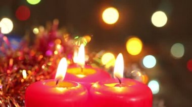 Üç yanan Noel mum yanıp sönen garland tarafından çevrili. Arka plan