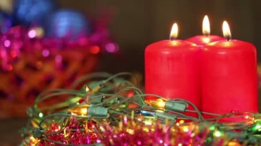 Üç yanan Noel mum yanıp sönen garland tarafından çevrili. Arka plan
