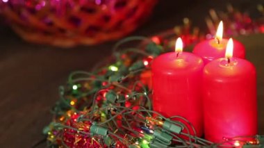 Üç yanan Noel mum yanıp sönen garland tarafından çevrili. Arka plan