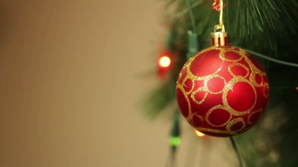 Bola roja en el árbol de Navidad con guirnaldas parpadeantes — Vídeos de Stock