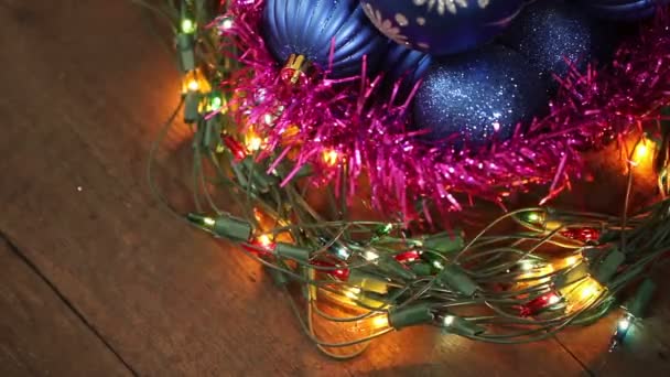 Bolas azules en una canasta de mimbre y guirnalda parpadeando. Fondo de Navidad — Vídeos de Stock