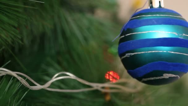 De blauwe bal met het is swingend op een kerstboom. — Stockvideo