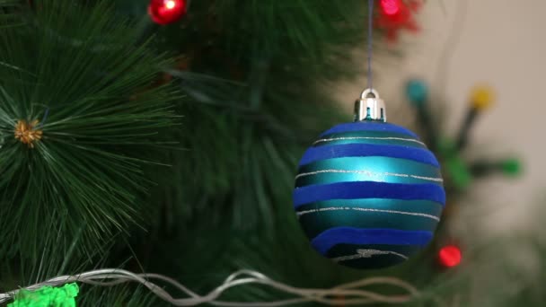 Mavi top bir Noel ağacına sallanıyor. — Stok video