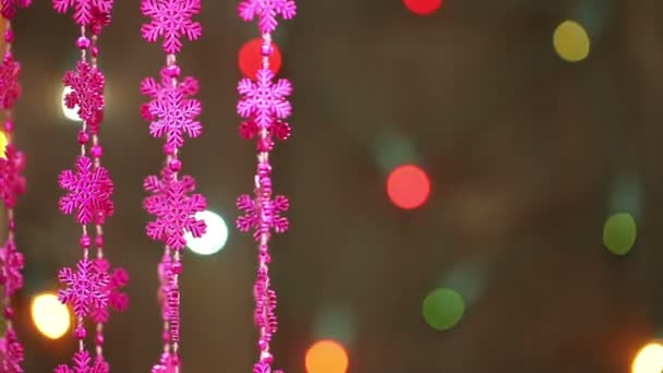 Garland of pink snowflakes on a background of a garland flashing. — Stock Video