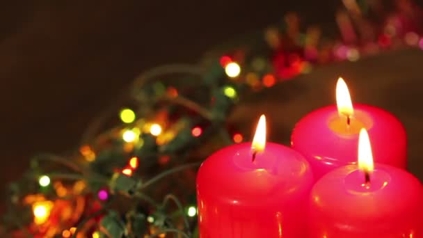 Tres velas de Navidad encendidas rodeadas de guirnaldas parpadeando. Contexto — Vídeos de Stock