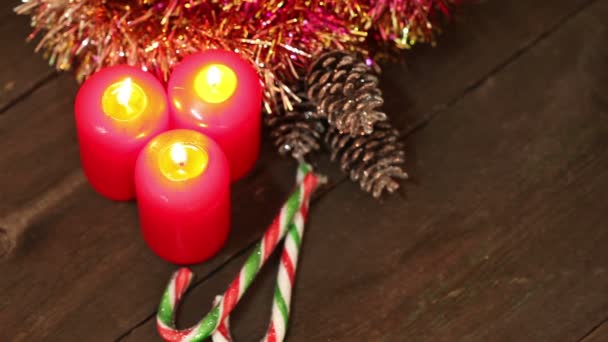 Decoraciones navideñas. Velas ardientes y juguetes en el fondo de guirnaldas parpadeando . — Vídeo de stock