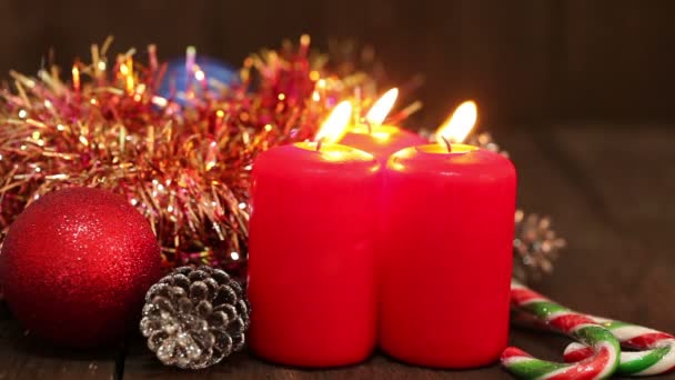 Decoraciones navideñas. Velas ardientes y juguetes en el fondo de guirnaldas parpadeando . — Vídeos de Stock