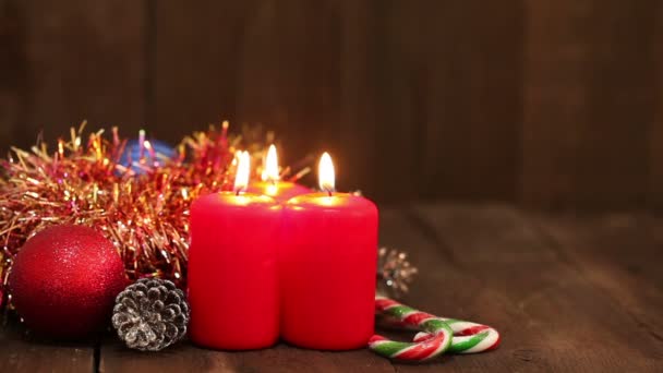 Weihnachtsdekoration. brennende Kerzen und Spielzeug auf dem Hintergrund blinkender Girlanden. — Stockvideo