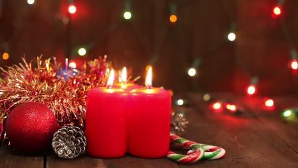 Decoraciones navideñas. Velas ardientes y juguetes en el fondo de guirnaldas parpadeando . — Vídeo de stock