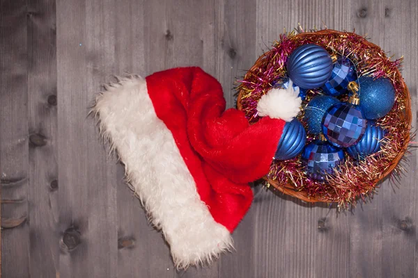 Sombreros de Santa y bolas azules de Navidad sobre un fondo de madera — Foto de Stock