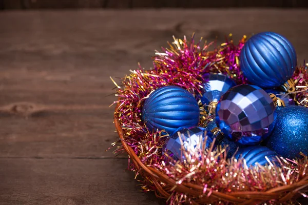 Blue Christmas balls in een mandje op een houten achtergrond — Stockfoto