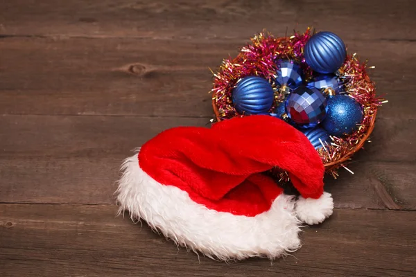 サンタの帽子と木製の背景に青のクリスマス ボール — ストック写真