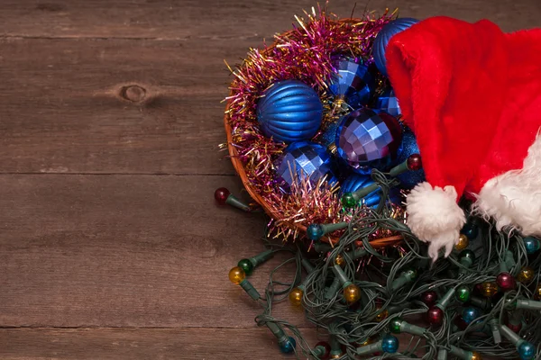 Noel Baba şapkaları ve ahşap bir zemin üzerine mavi Noel topları — Stok fotoğraf