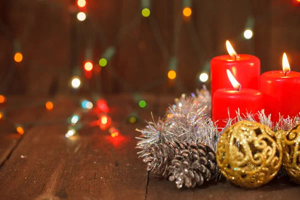 Tre brinnande ljus och gyllene bollar. jul bakgrund — Stockfoto