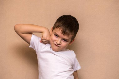 Çocuk kameranın önünde şımarır. Altı yaşındaki bir çocuğun portresi..