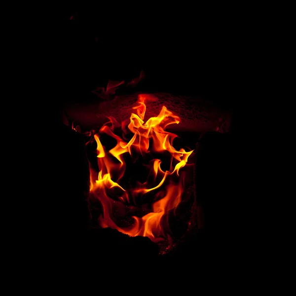 Las llamas estallan desde la cámara de combustión del horno, sobre un fondo negro — Foto de Stock