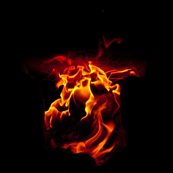 Flames erupt from the combustion chamber of the furnace, on a black background — Stock Photo, Image