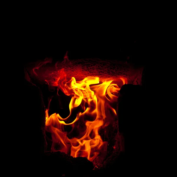 Flames erupt from the combustion chamber of the furnace, on a black background — Stock Photo, Image