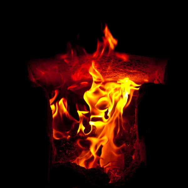 Flames erupt from the combustion chamber of the furnace, on a black background — Stock Photo, Image