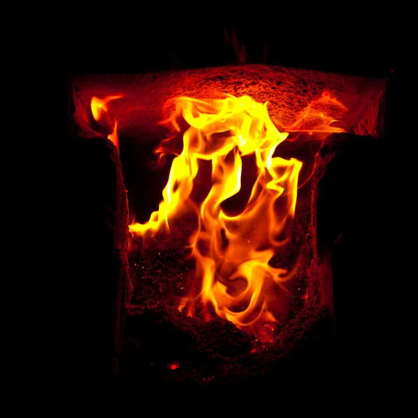 Flames erupt from the combustion chamber of the furnace, on a black background — Stock Photo, Image