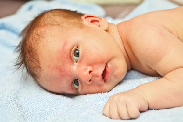 Newborn boy lying on the towel and looking at the camera — Stock Photo, Image