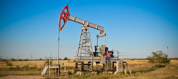 Oil pump on a background of a stormy sky, panorama — Stock Photo, Image