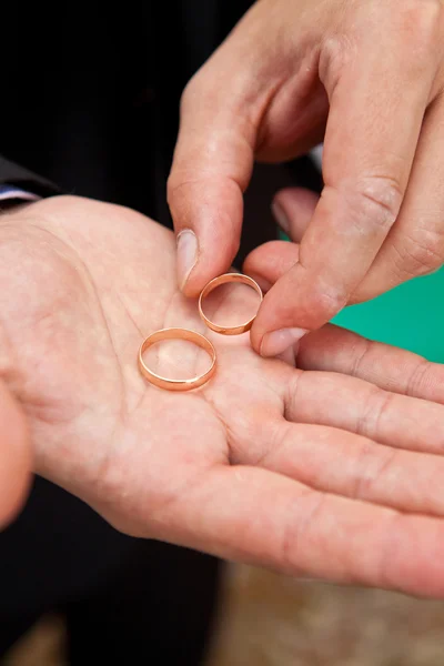 Anéis de casamento na palma da mão do noivo closeup — Fotografia de Stock