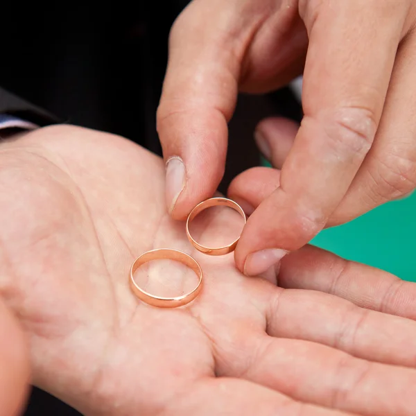 Anéis de casamento na palma da mão do noivo closeup — Fotografia de Stock