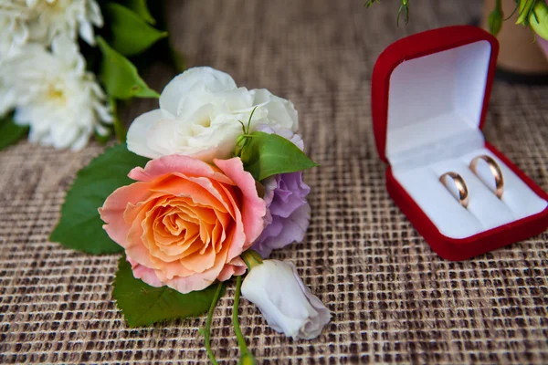 Свадебные кольца в коробке и бутоньерке, мелкая глубина резкости — стоковое фото
