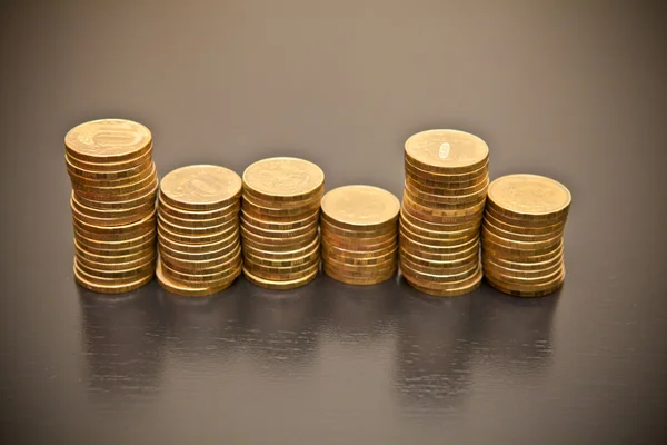 Montón de monedas sobre un fondo de madera negro —  Fotos de Stock