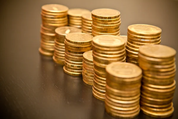 Montón de monedas sobre un fondo de madera negro — Foto de Stock