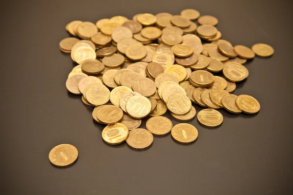 Monedas dispersas sobre fondo negro — Foto de Stock