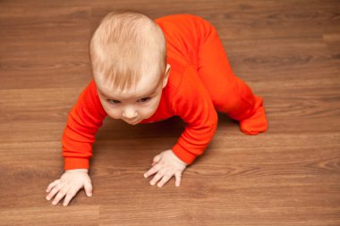 bebek tahta zeminde sürünüyor.