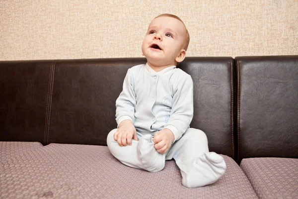 Niño en un traje azul sentado en un sofá —  Fotos de Stock