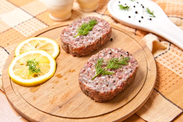 Escalope avec tranches de citron sur une planche à découper à côté de la casserole — Photo