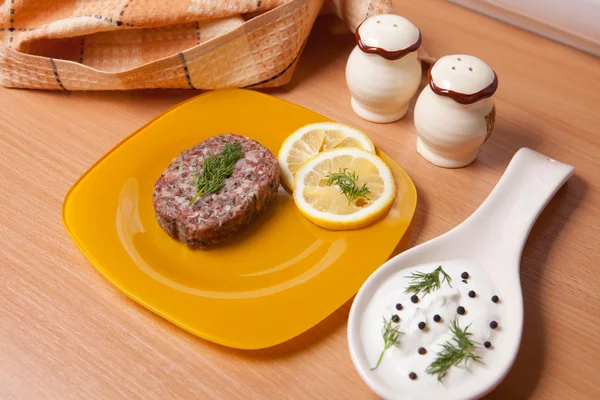 Burger on a plate next to the saucepan — Stock Photo, Image