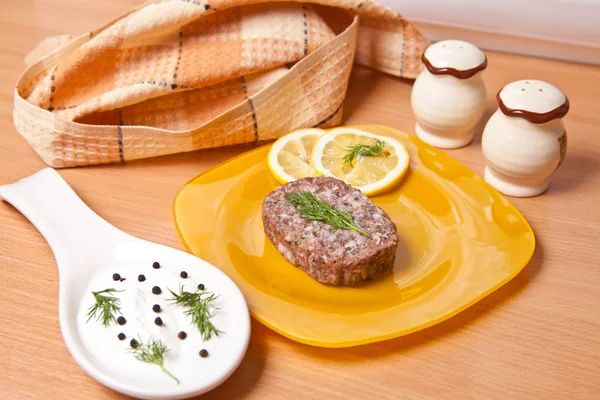 Burger on a plate next to the saucepan — Stock Photo, Image