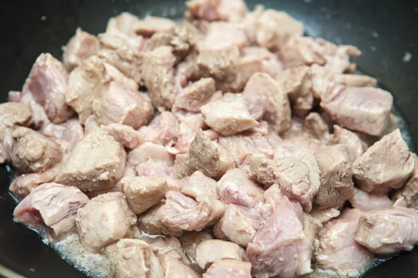 Carne cortada em pedaços fritos em uma panela — Fotografia de Stock