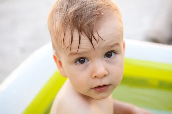 Child bathes in inflatable pool outdoors, close-up portrait Royalty Free Stock Photos