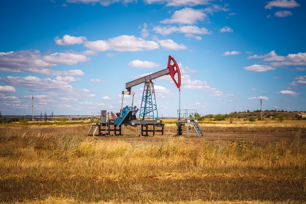 Oliepomp in het veld op een bewolkte hemel achtergrond — Stockfoto