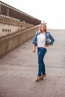 Şehir havada poz denim elbiseli güzel kız